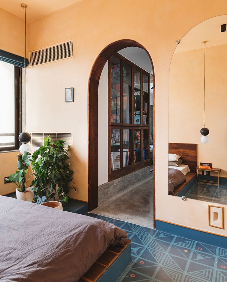 Dormitorio con acceso en forma de arco y vista hacia estantería
