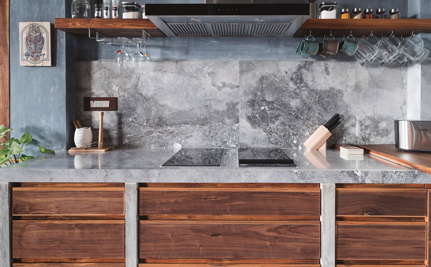 Encimera y frente de trabajo en mármol de la cocina, equipada con mobiliario de madera en acabado natural