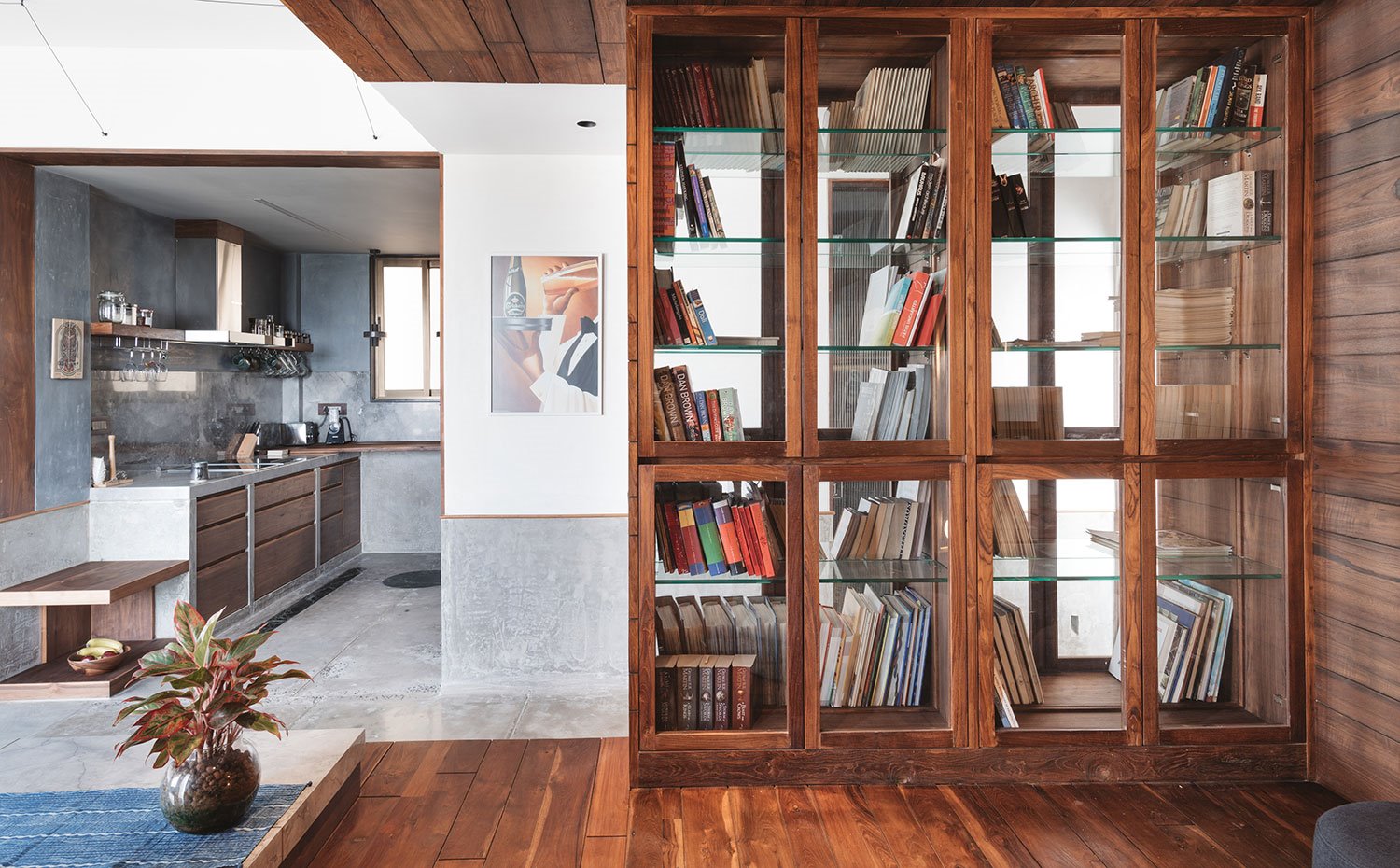 Vitrina de cristal y madera para libros en estructura de madera elevada junto a cocina