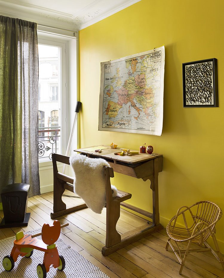 Dormitorio con pupitre vintage de madera frente a mapa en pared
