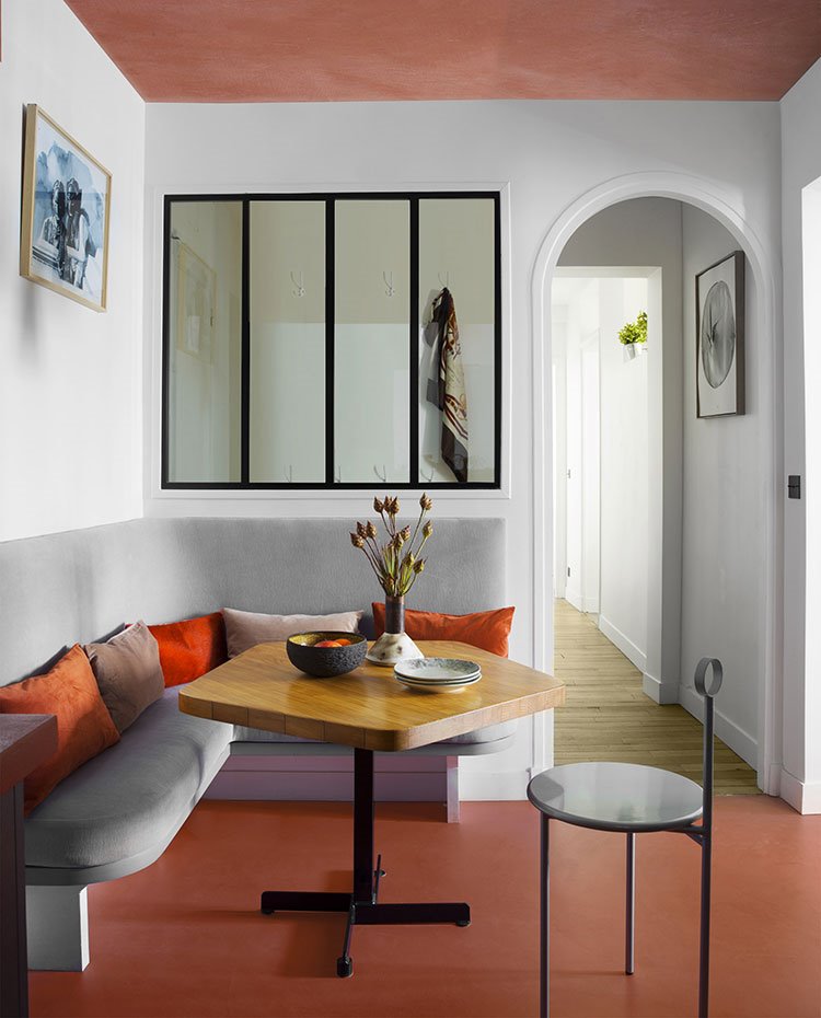 Zona office con bancada, mesa de forma poligonal con sobre de madera, silla escultural, marco puertas abovebado