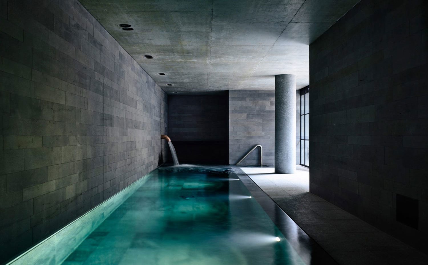 Piscina interior recubierta de piedra grisácea