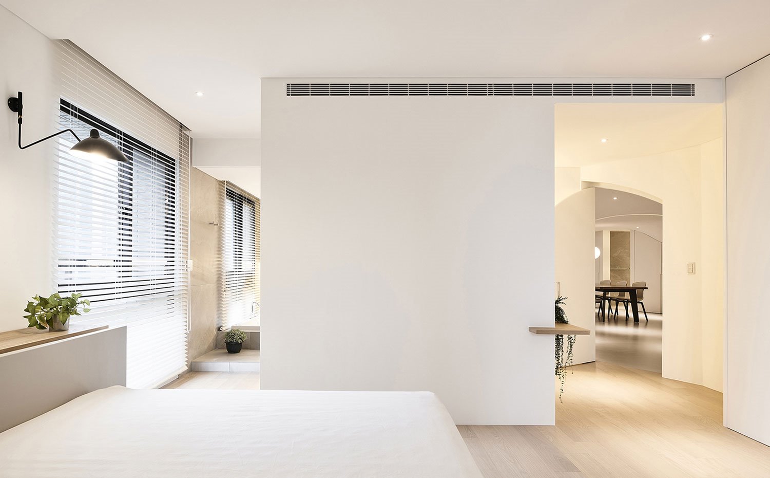 Dormitorio con estores en ventana, aplique negro, suelo de madera