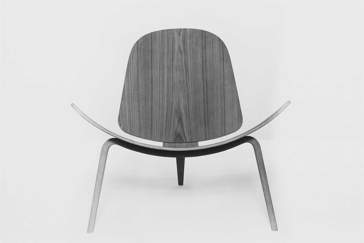 La silla CH07 (1963) destaca por su amplio asiento curvo y sus tres patas simétricas.