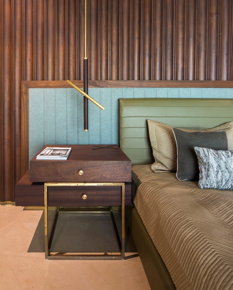 Detalle mesilla de noche de dormitorio, en madera y estructura dorada y luminaria suspendida a juego