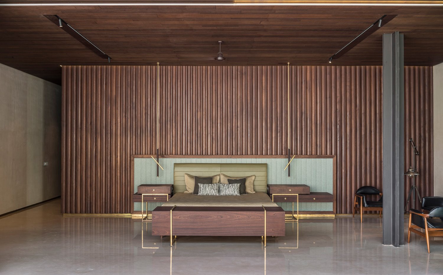 Dormitorio con revestimiento ondulante de madera, cabecero acolchado verde y estructura de madera y acero dorado