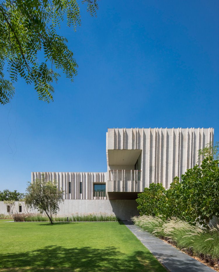Exterior vivienda con camino de piedras delitado por zona ajardinada