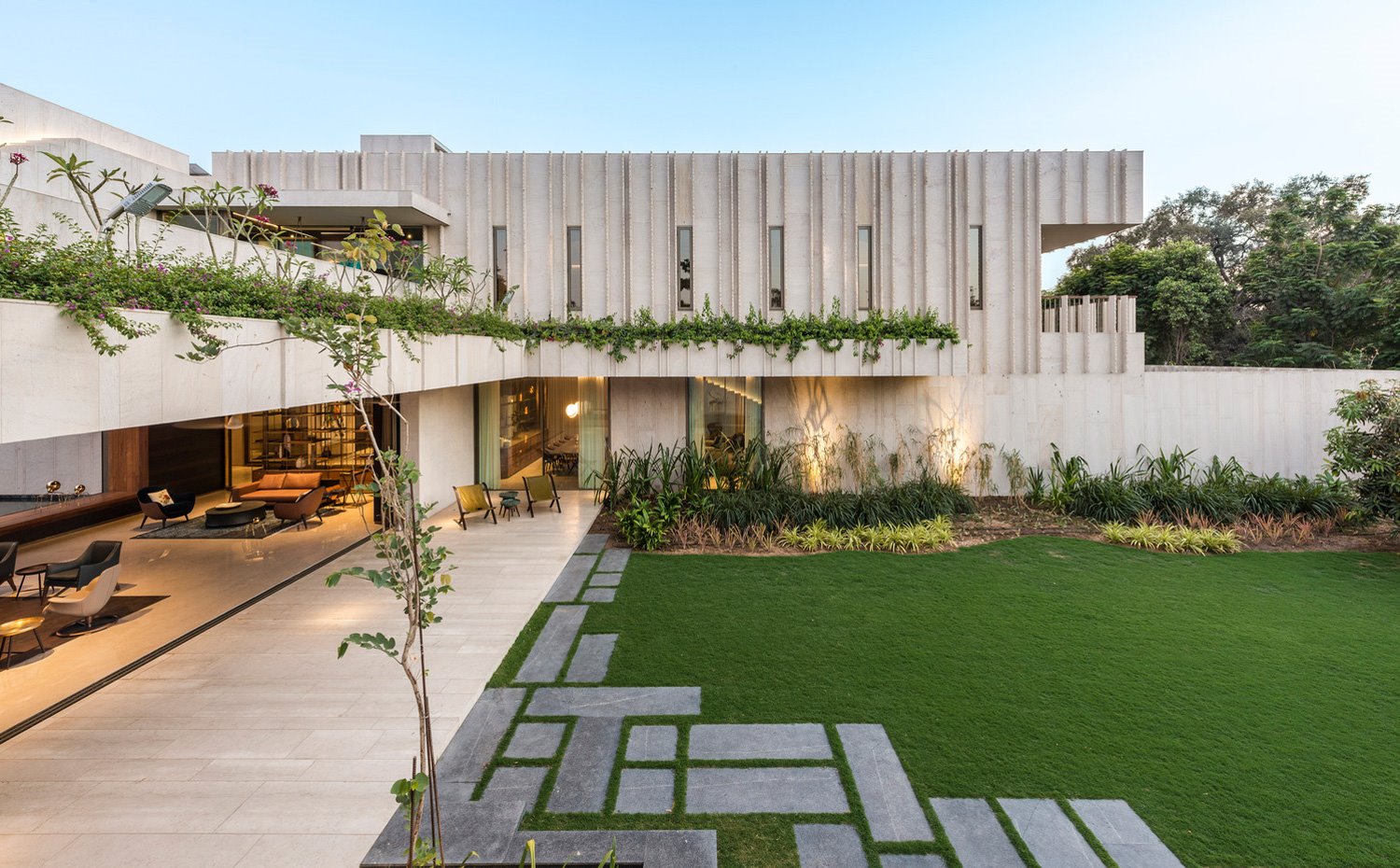 Terraza exterior junto a salón que se extiende a zona ajardinada