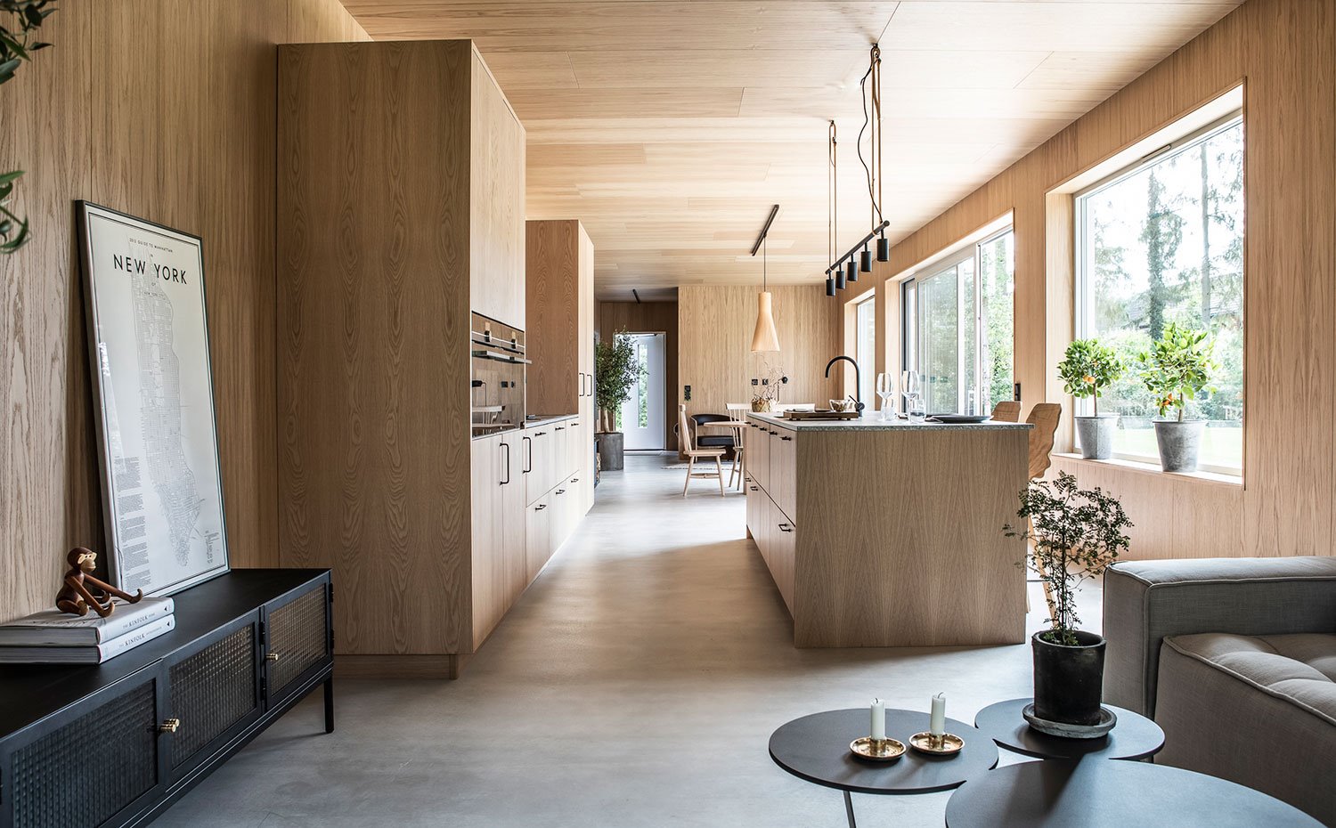Cocina abierta a comedor y sala de estar, todo revestido de madera natural