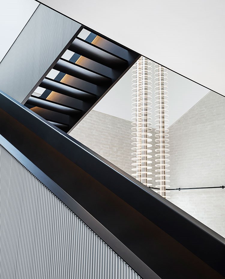 Escaleras en negro y gris, luminarias a gran altura