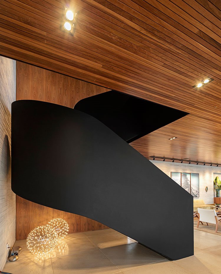 Detalle escaleras por parte trasera con luminaris circulares de suelo, revestimiento alistonado de madera en techo