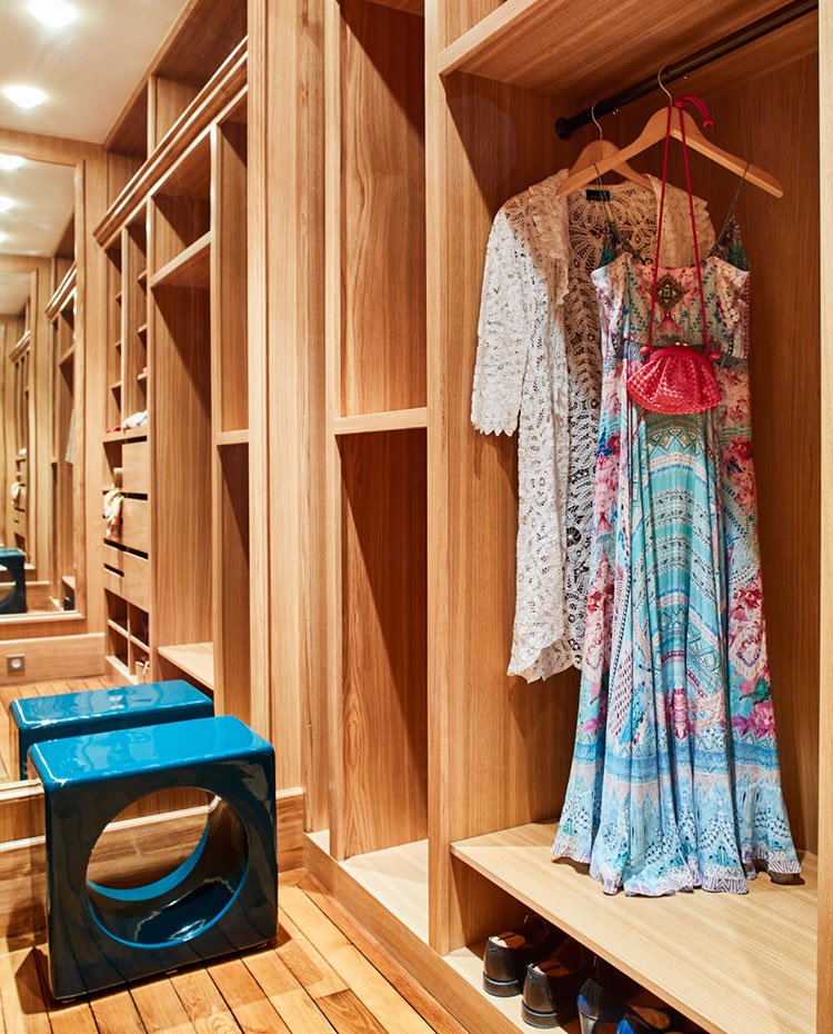 Vestidor con suelo y carpintería en madera natural, mesilla auxiliar en turquesa