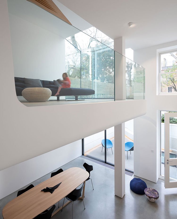 Barandilla del nivel superior vivienda en cristal transparente con vistas al comedor inferior