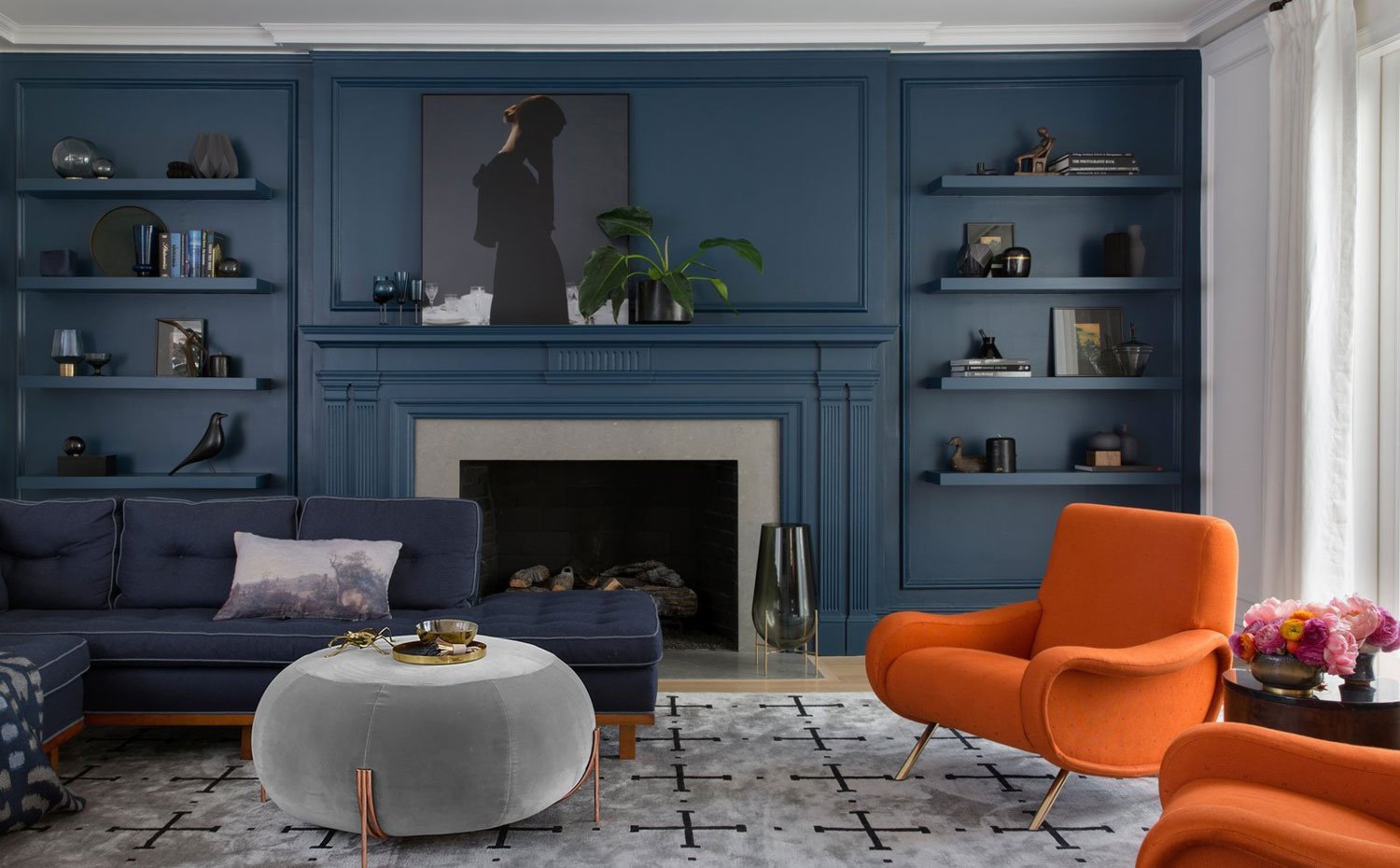 salon-con-paredes-y-baldas-en-color-negro-cobalto-sofa-en-negro-sobre-alfombra-gris-con-motivos-en-negro-butacas-naranjas-y-puf-en-gris 5323865e 1500x930