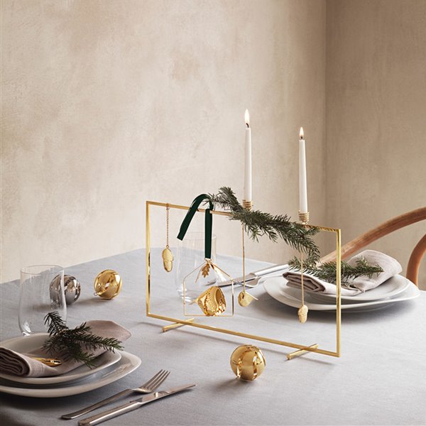 Candelabro y adornos dorados navideños de aspecto moderno.