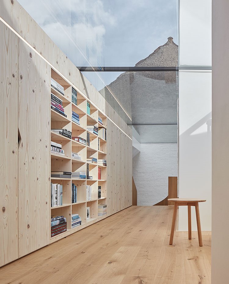 Armarios y estantería de madera natural, suelo y taburete de madera, techo de cristal