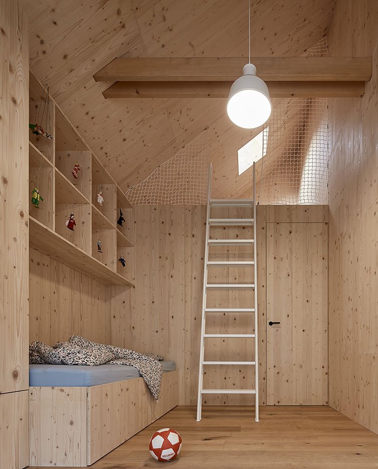 Dormitorio infantil revestido totalmente de madera con altillo
