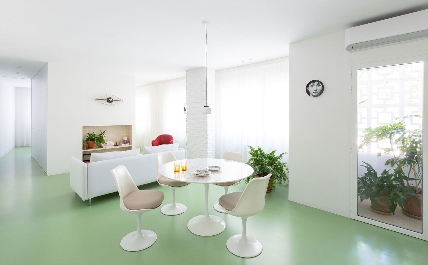 Comedor-diáfano-con-salón-y-balcón-con-vegetación-exterior