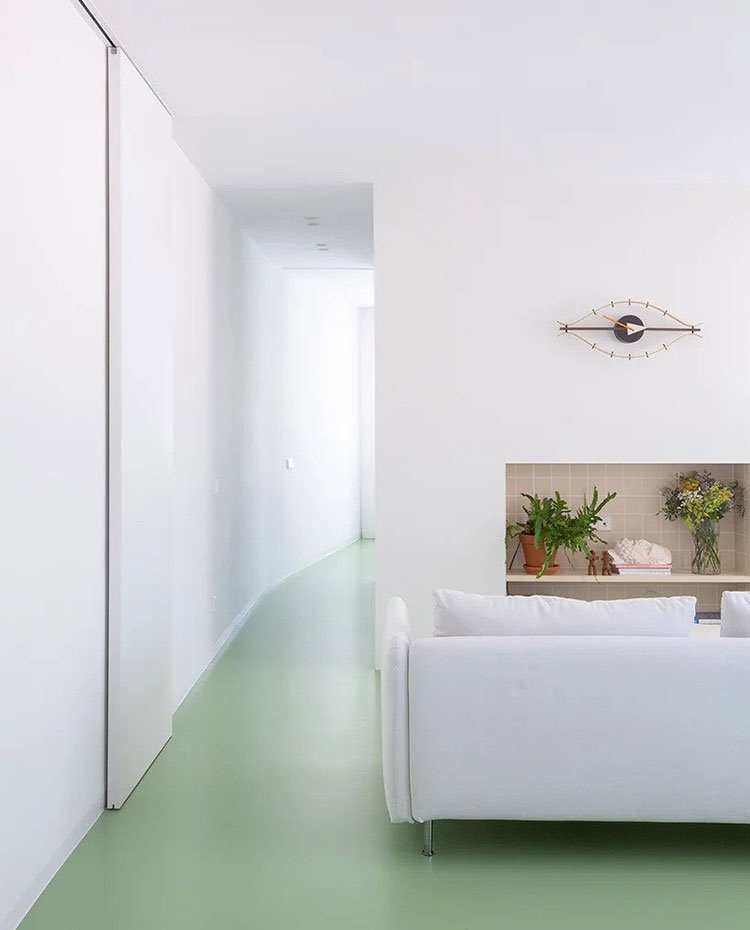 Zona de paso con puertas correderas, sofá blanco hacia hornacina 