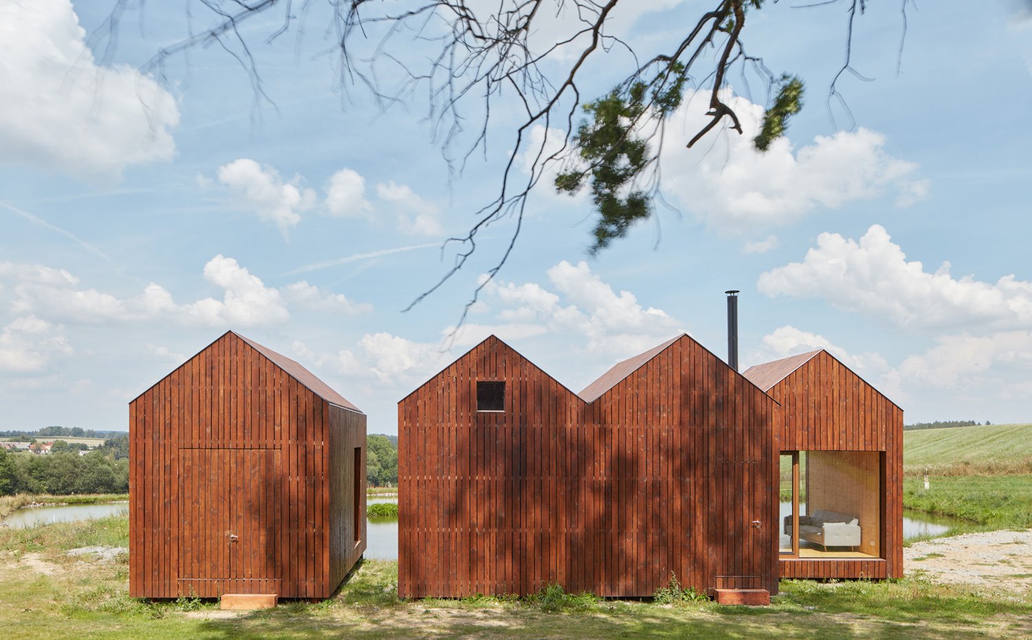 Vista exterior de la vivienda con las diferentes unidades a dos aguas con fachada de madera