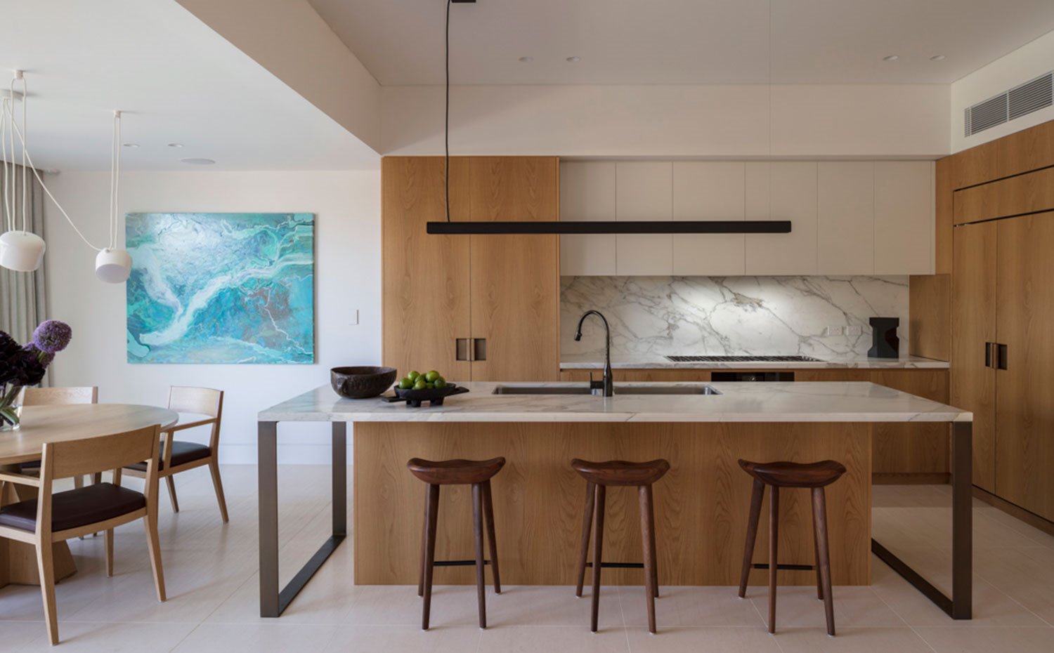 Cocina de madera y mobiliario en crido con isla de trabajo y office y mesa de comedor