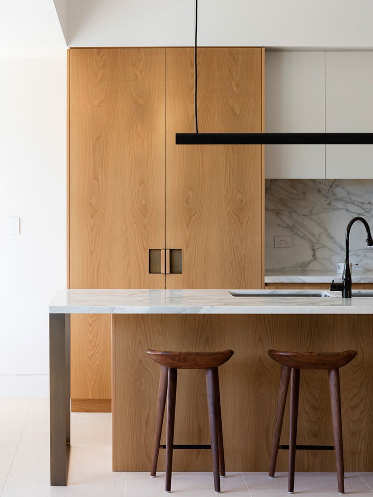 Detalle zona de office frente a armarios de cocina en madera natural y frentes de tonos ocres