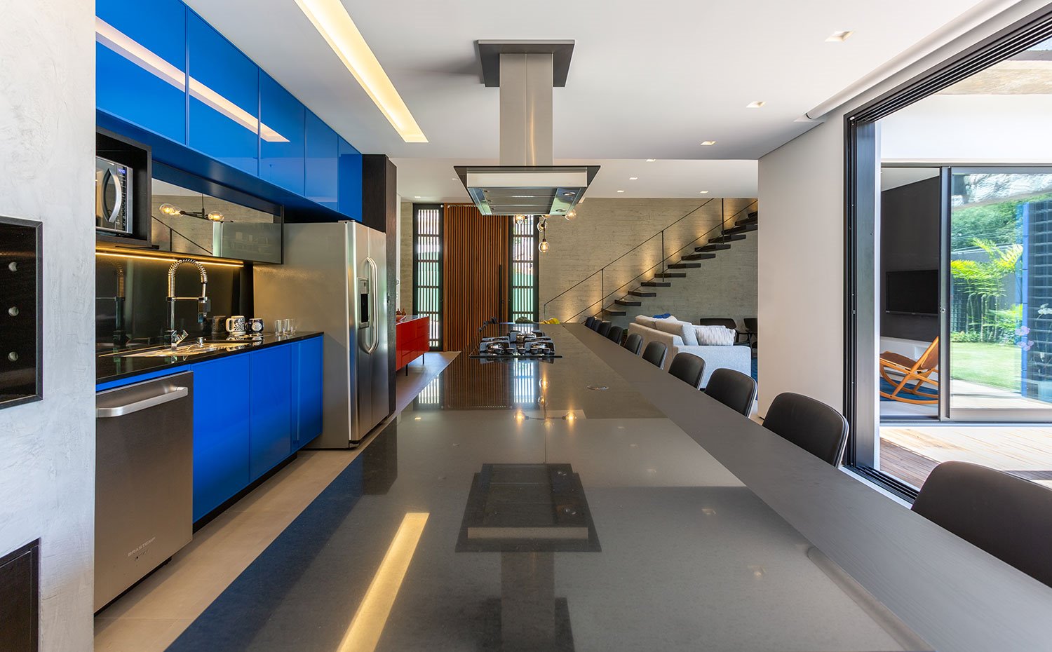 Encimera de isla con zona de trabajo y cocción, mobiliario en azul y acabado en inox