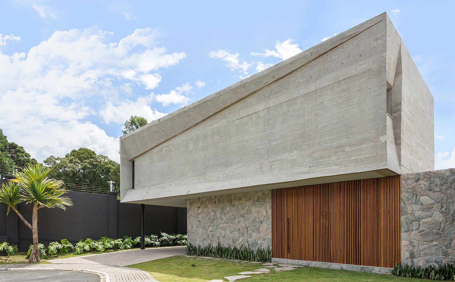 Exterior vivienda con fachada de hormigón y frente con listones de madera