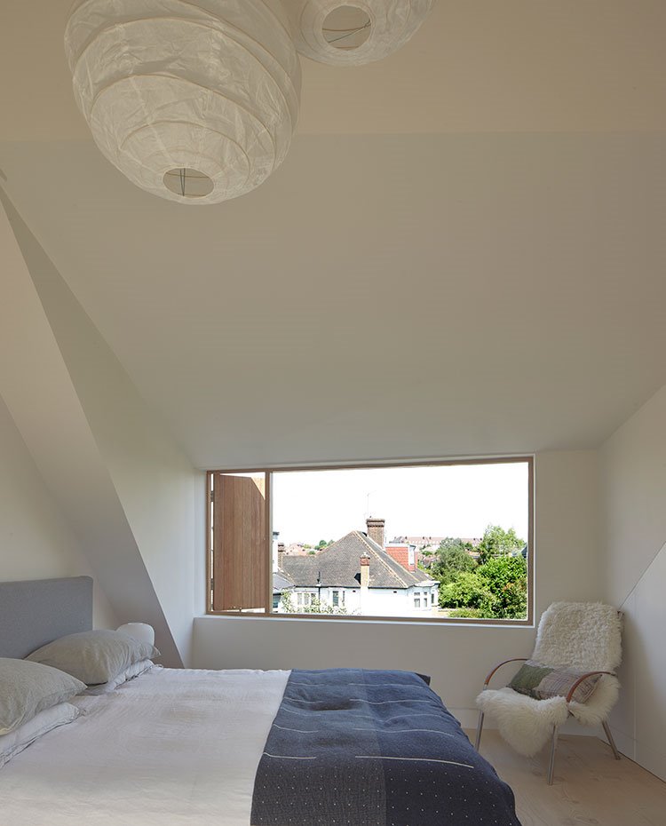 Dormitorio con cubierta inclinada, amplia ventana horizontal, luminaria suspendida de papel 