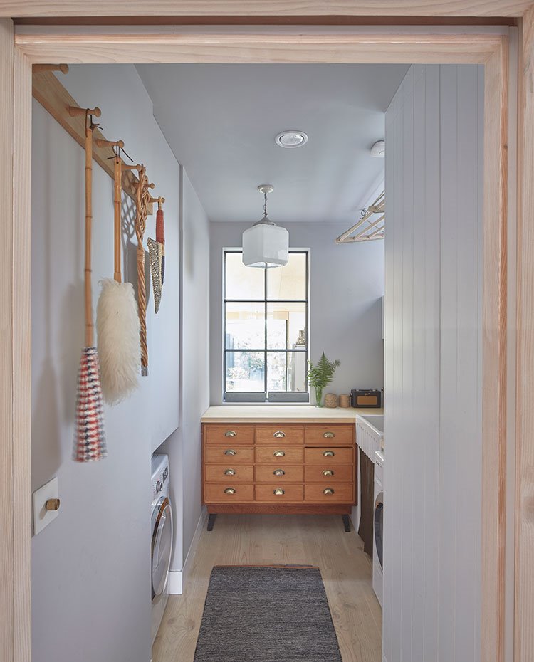 Zona de lavadero con mueble vintage y hueco para lavadora, suelo de madera