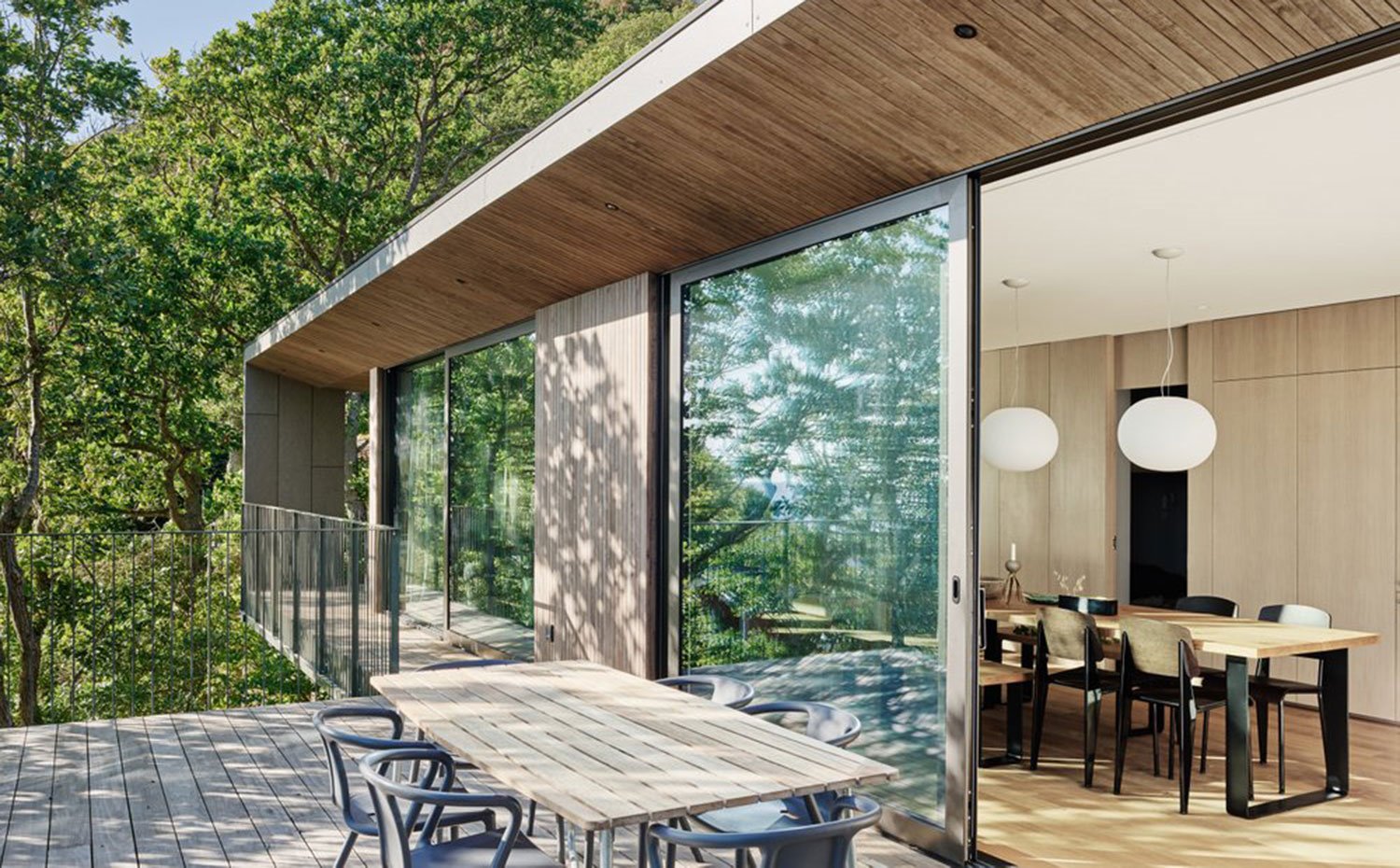 Comedor exterior e interior con apertura corredera, entorno antural, revestimiento y pavimento de madera