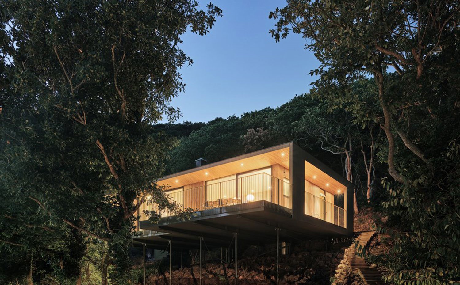 Vista a distancia con vivienda de noche elevada sobre ladera