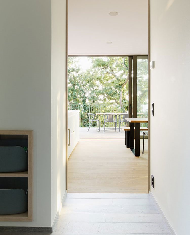Zona de paso interior vivienda, paredes blancas, moviliario integrado de madera