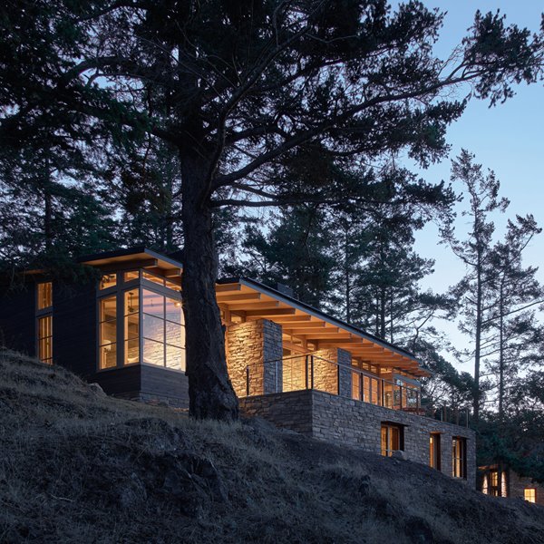 Una bucólica casa de piedra y madera rodeada de bosque