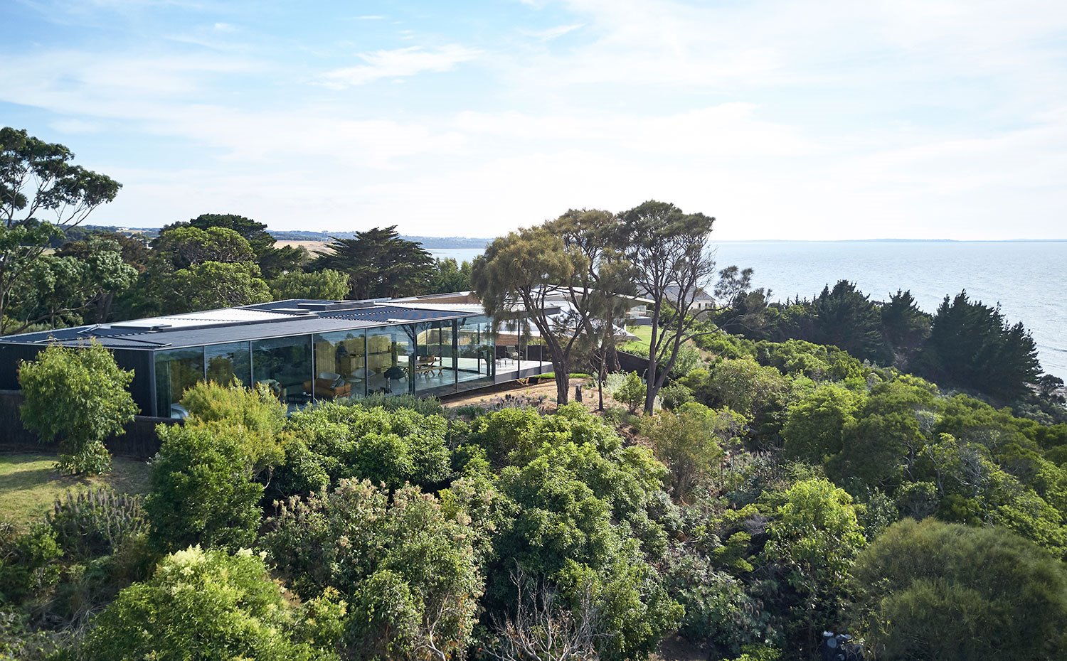 Vista exterior de la vivienda con el mar de fondo