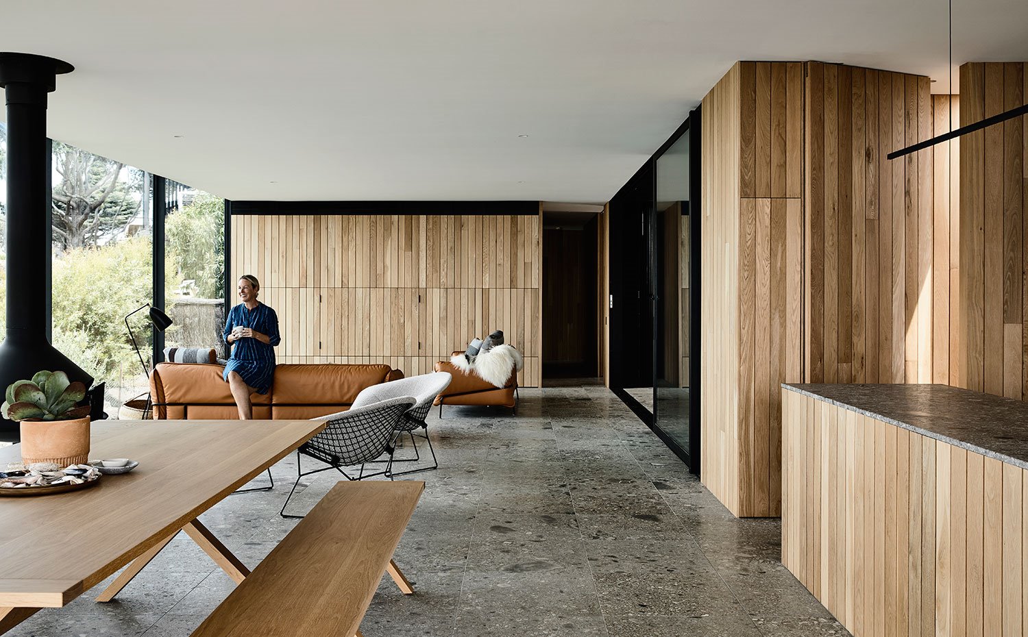 Zona de día con cocina, comedor y salón, todo revestido de madera alistonada