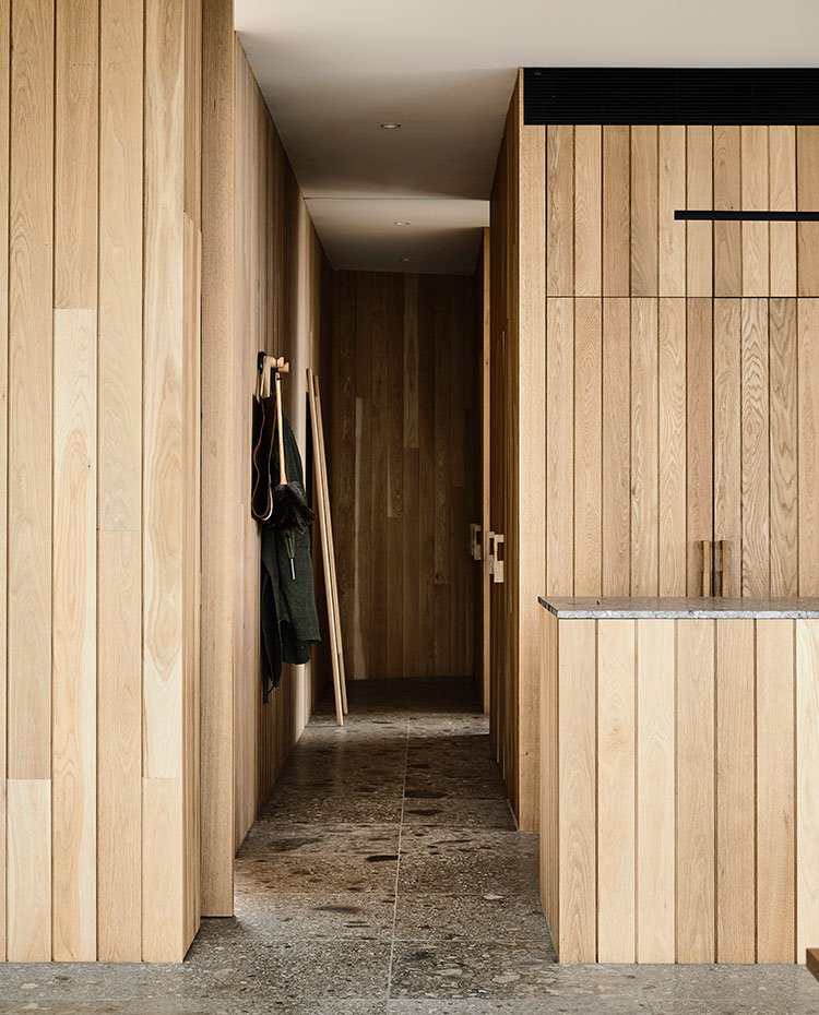 Zona de paso desde cocina a dormitorios con revestimiento todo armonizado en listones de madera
