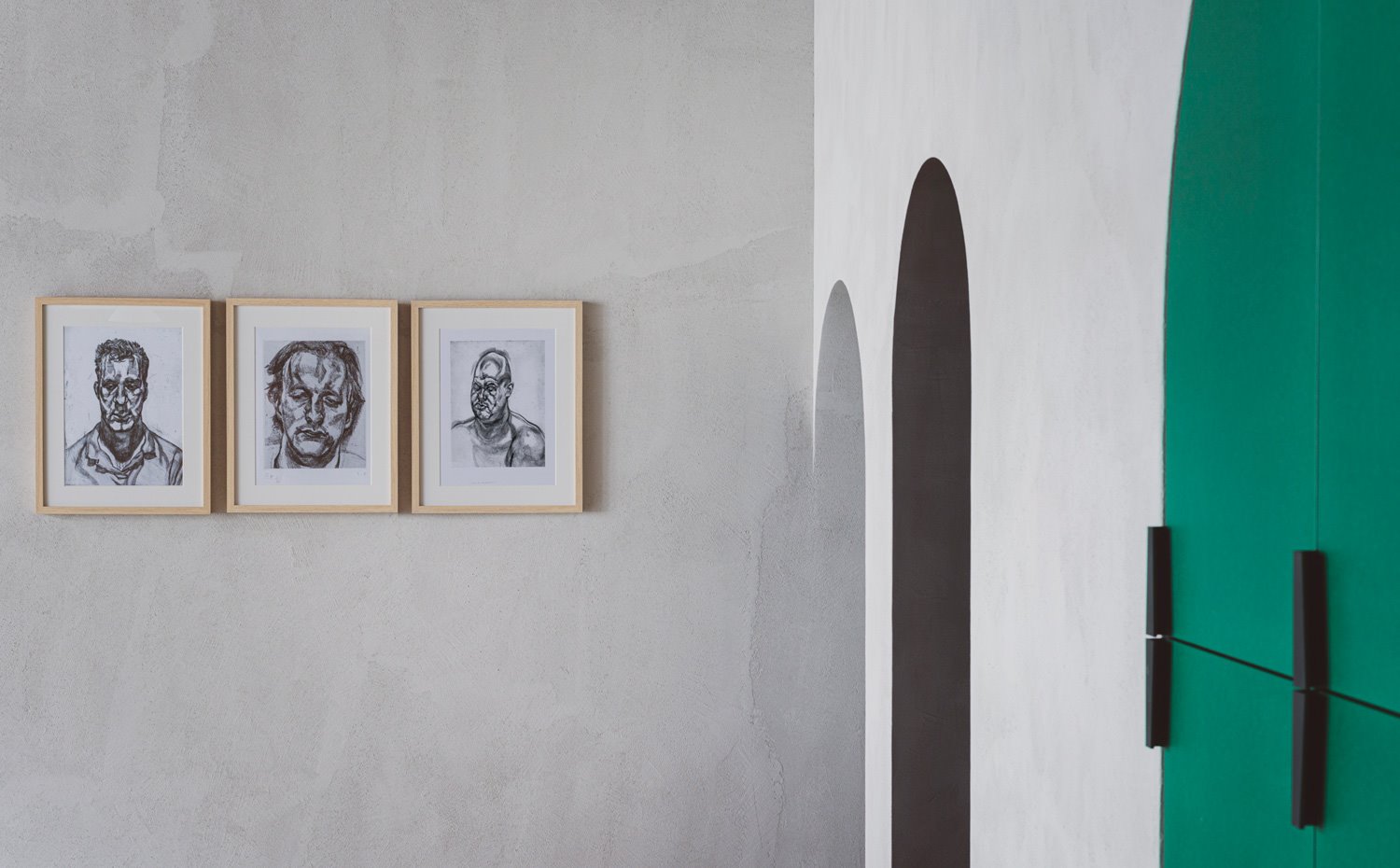 Detalles de pared en gris con armarios integrados en verde y accesos con formas arqueadas