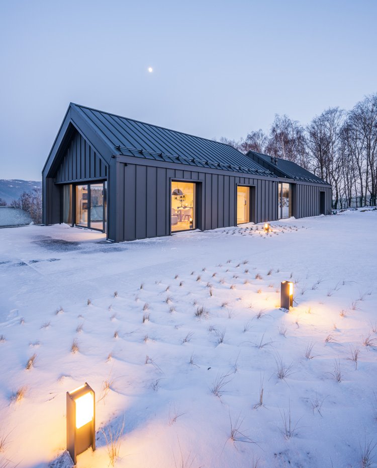 Vista exteror de la planta superior de la vivienda con luminarias encendidas