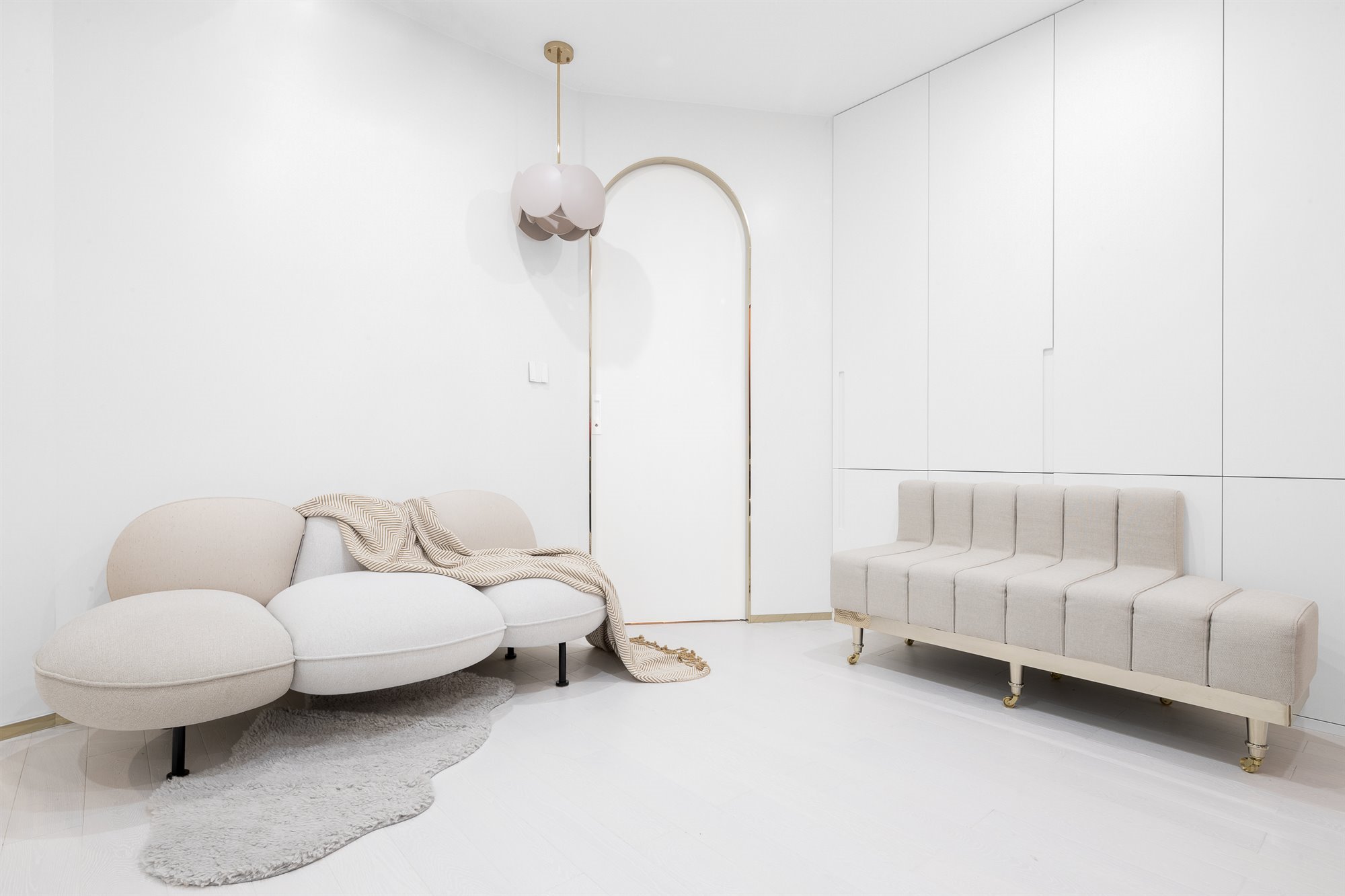 comedor y salon en colores neutros con sofas zonas de almacenaje lampara y alfombra