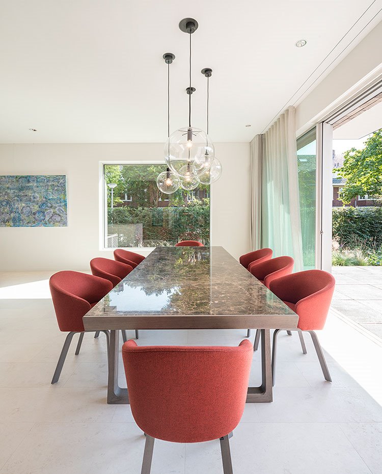 Mesa de comedor con encimera de mármol y sillas rojas