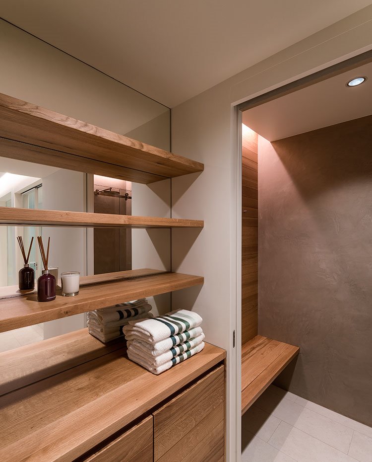 Zona de vestidor con mobiliario en madera de acabado 