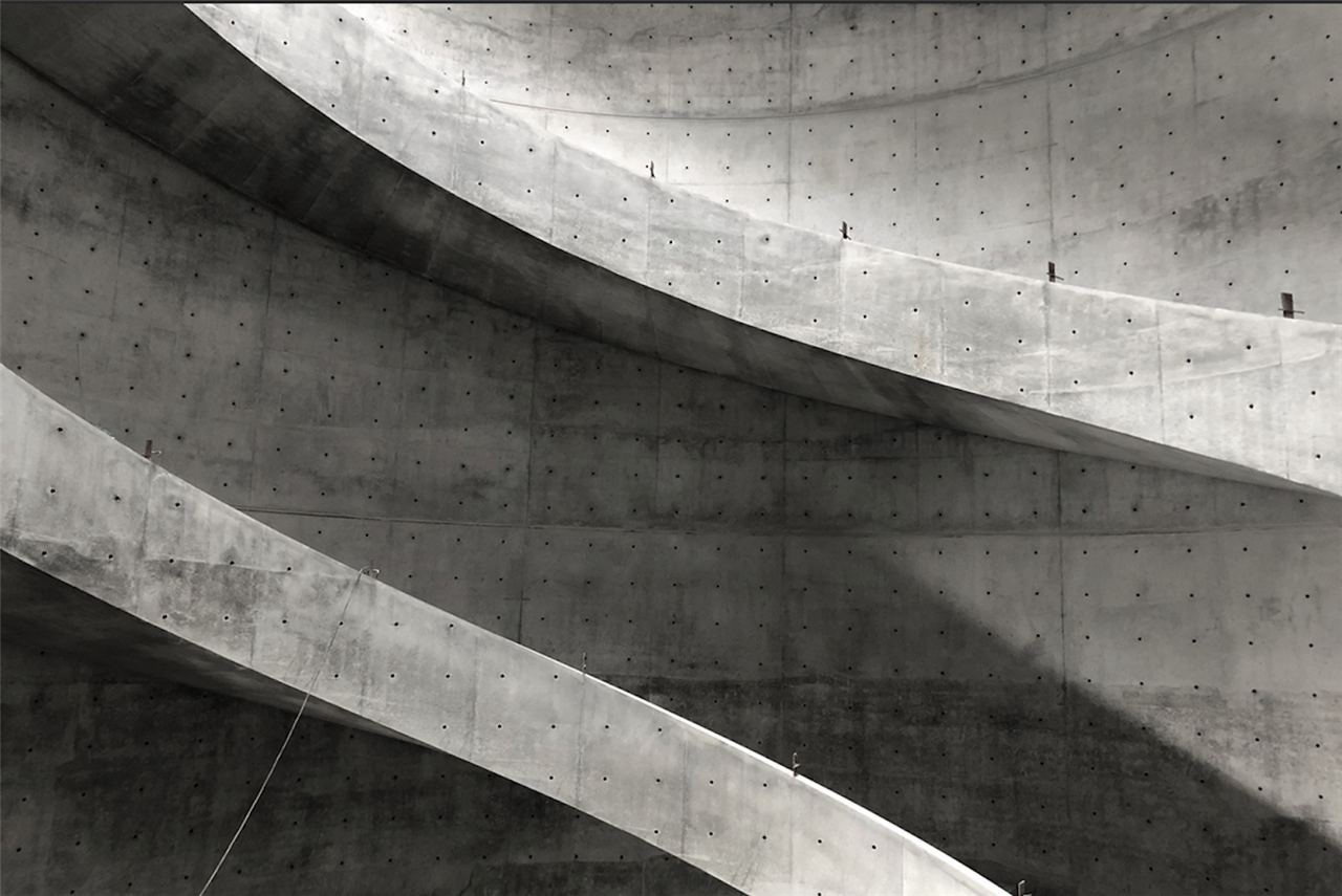 Un detalle de la estructura de hormigón de la escalera de caracol de doble hélice que asciende en torno a una claraboya circular de cristal.