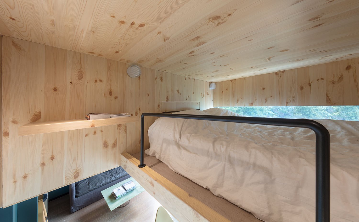 Dormitorio en hueco superior de vivienda, totalmente revestido de madera