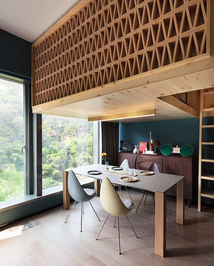 Mesa comedor bajo estructura a modo de celosía de madera, aperturas laterales con cerramiento acristalado