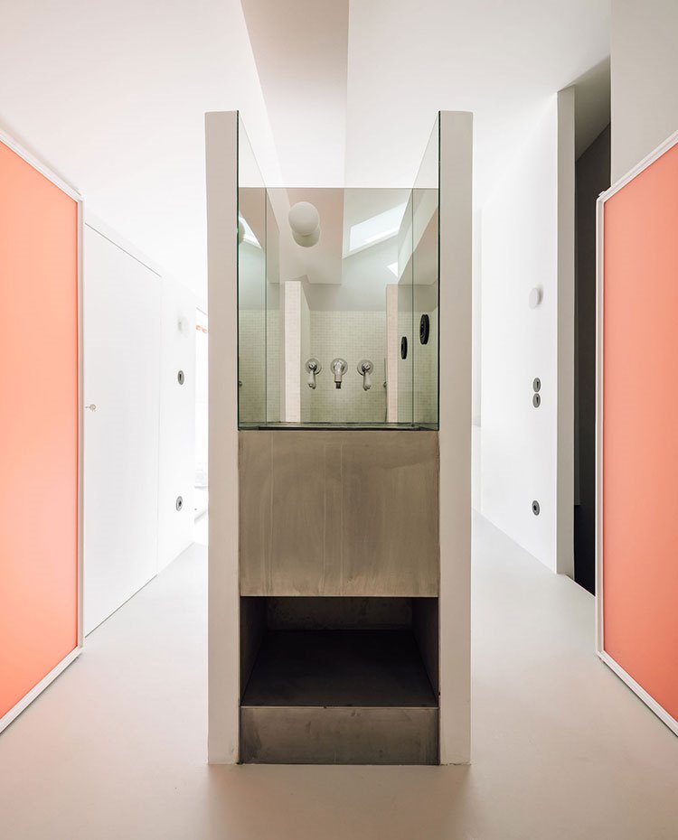 Lavamanos entre zonas de paso con puertas color teja a ambos lados