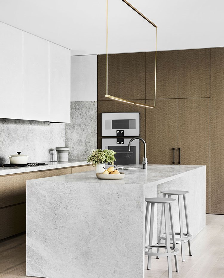 Cocina con isla de trabajo y office revestida de piedra