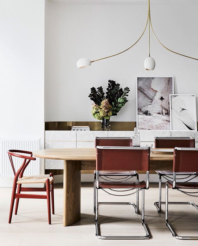 Comedor con luminaria suspendida de tres brazos, mueble trasero suspendido con jarrón
