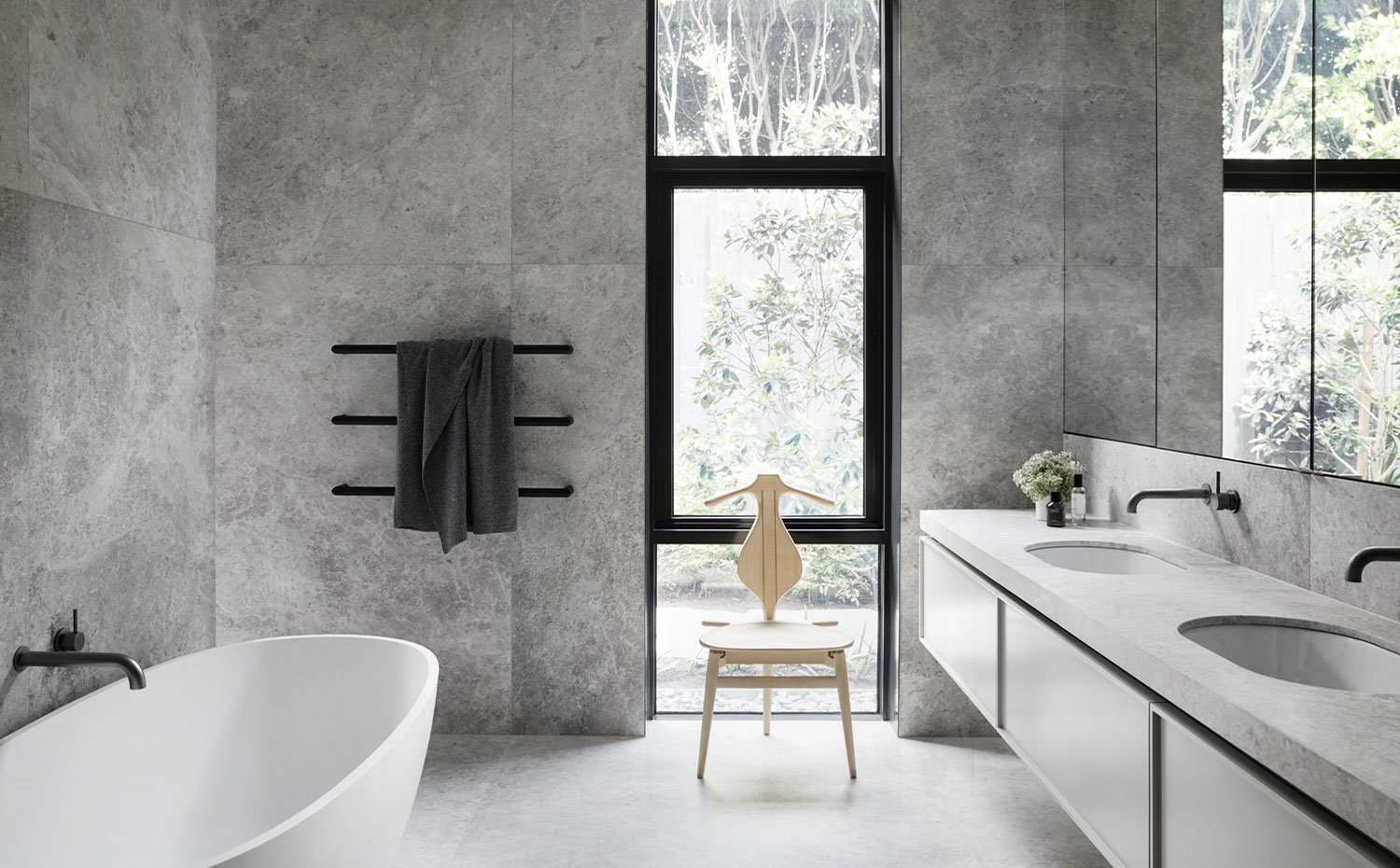 Cuarto de baño con bañera exenta, asiento escultural y módulo de lavabo suspendido