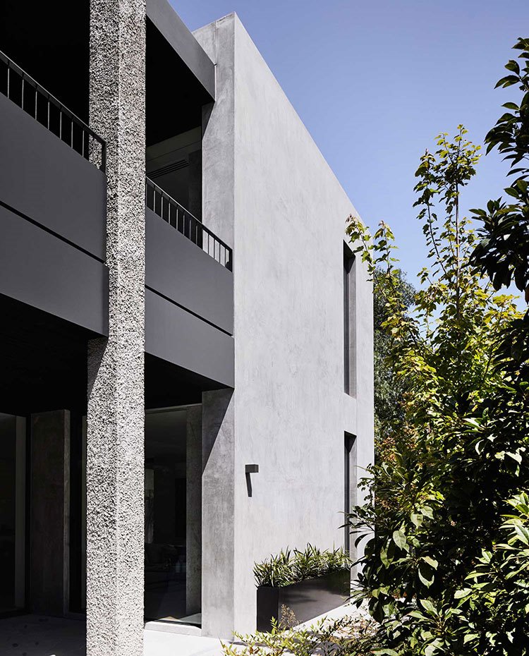 Fachada exterior con estructura de hormigón y balcones de madera oscura